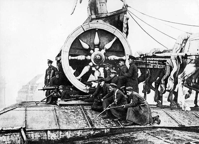 Protirevolucionarne sile na Brandenburških vratih med Spartakovo vstajo, Berlin, 7. januar 1919, New‑York Tribune, 16. februar 1919; vir: Wikimedia Commons, File: Soldiers the Brandenburger Tor during the Spartacist uprising Jan 7 1919.jpg, javna domena (PD‑US); dostop 14. 1. 2026. 